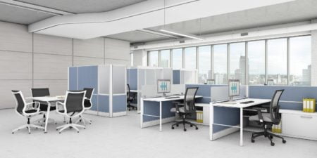 An array of Compile model workstations in the office. Each workstation has a rollaway chair, computer and set of storage to one side. At the side is a small table with four chairs placed at it, for collaborative work.