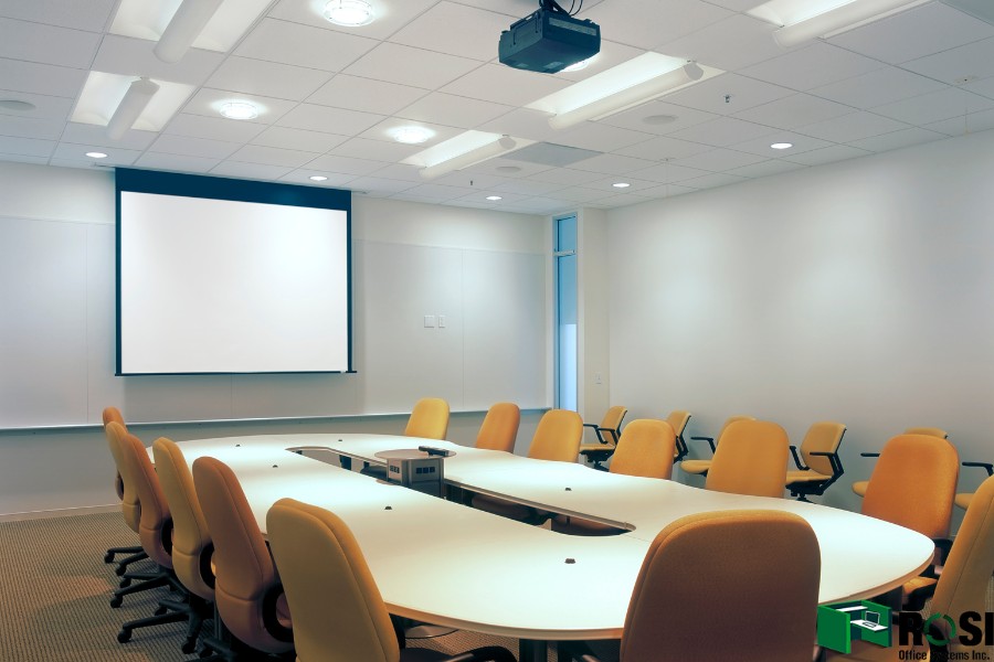 Conference room table with chairs and projector screen